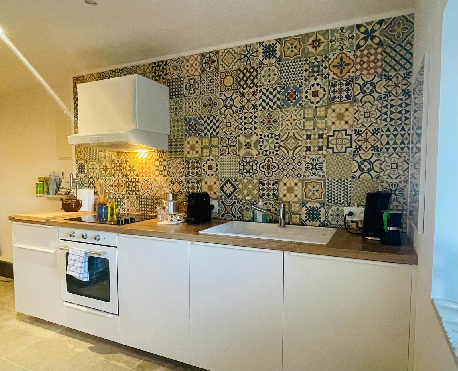 Keuken met mozaïek-tegelwand.